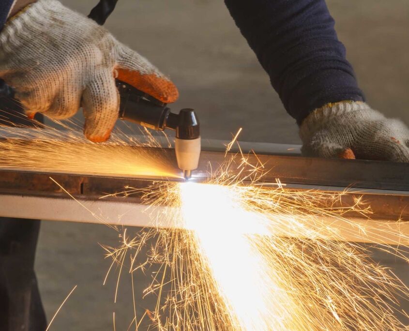 Close up view of welding worker using plasma cutter