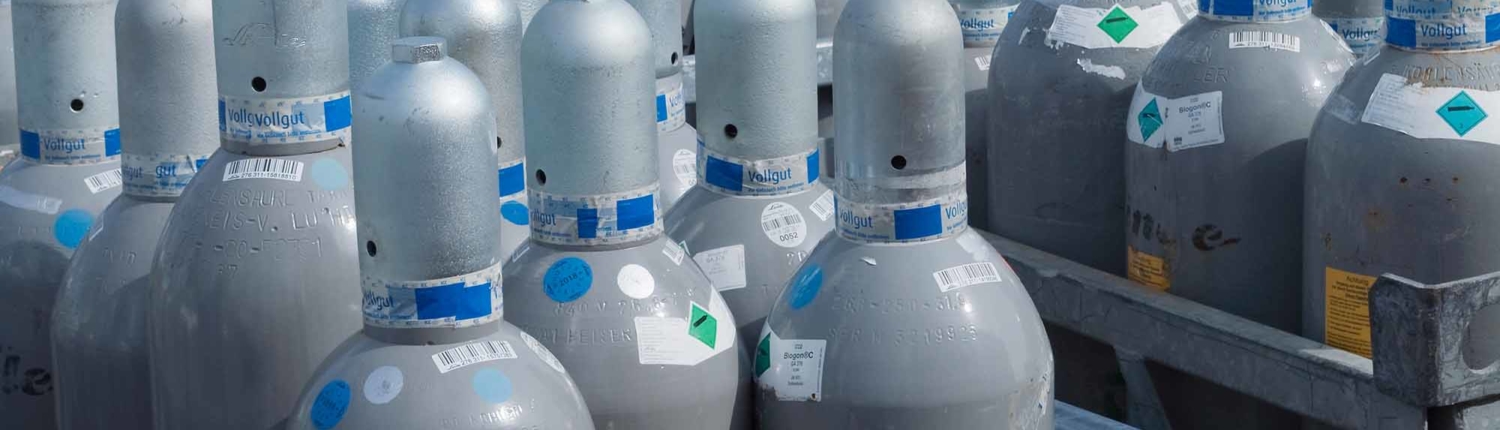 Industrial Size Gas Bottles 1_ several racks of grey industrial-sized gas canisters