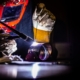Worker using tig welder on meta pipe pieces