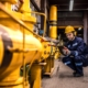 Industrial technician checking gas pipeline installations inside refinery