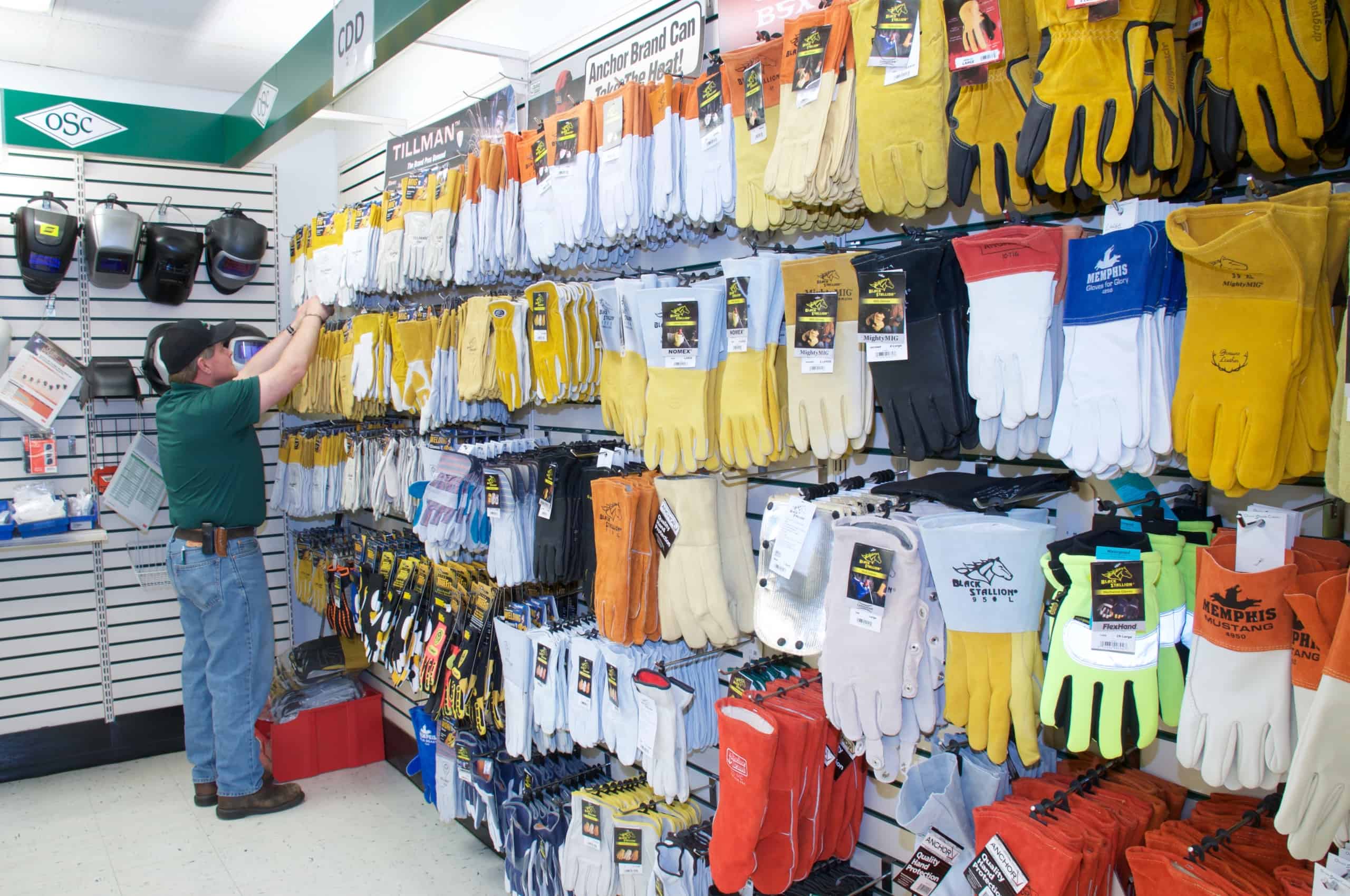 photo of OSC welding supply store with welding gloves and team member putting items on shelves