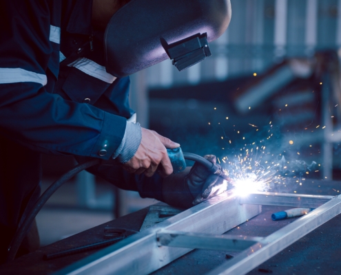 masked engineer using welding equipment