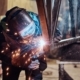 Person welding metal beams togetehr