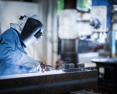 Industrial welder welding fabricated construction in factory
