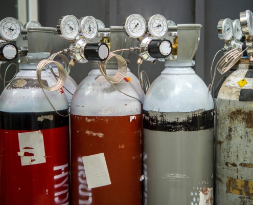 Side view of two red hydrogen gas tanks